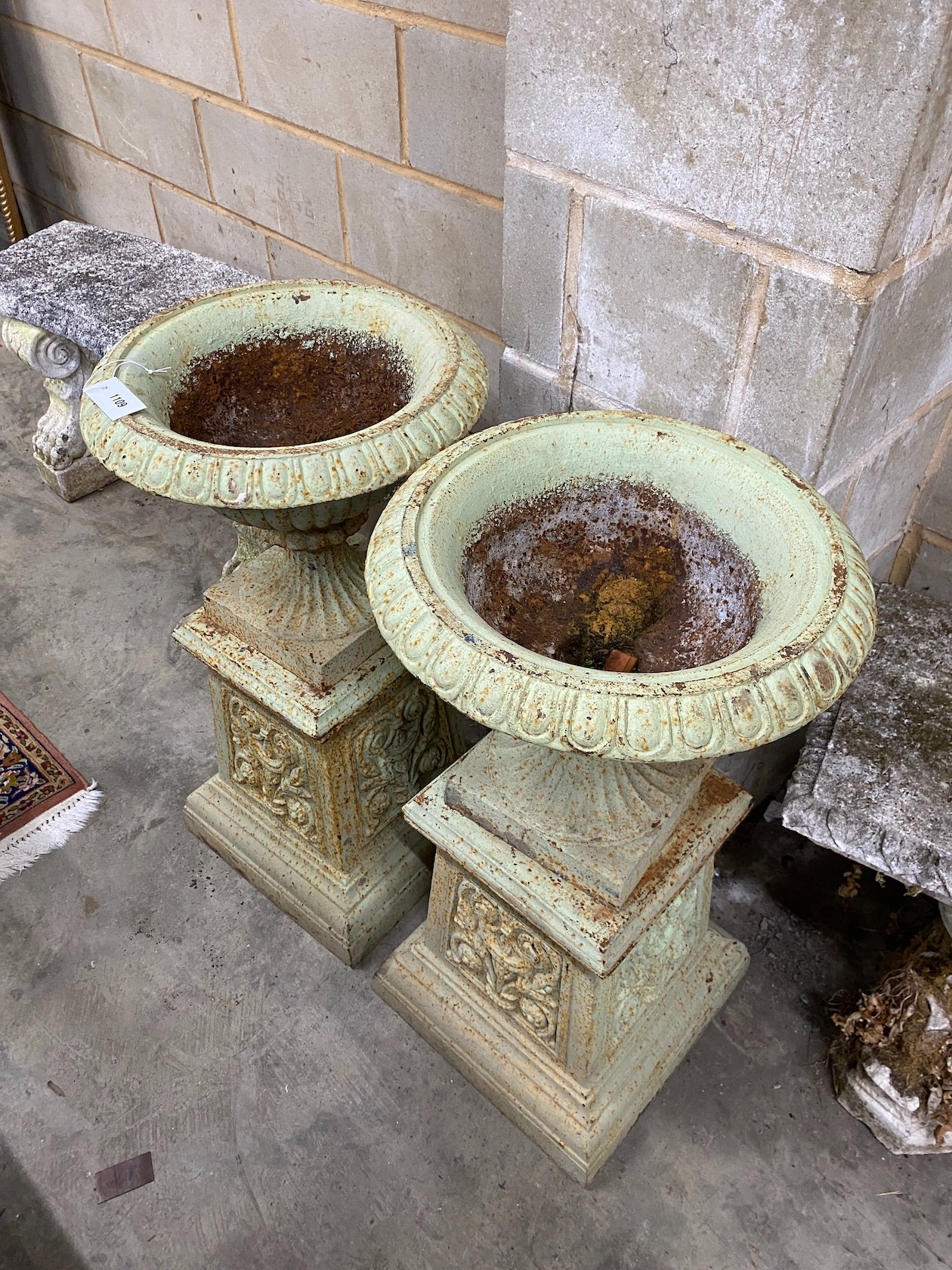 A pair of Victorian cast iron garden urns and pedestals, diameter 43cm height 80cm